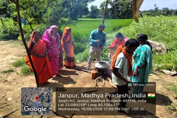 धान के खेत के पास चूल्हे पर रखे बर्तन के आसपास खड़े किसान और प्राकृतिक घोल तैयार करता एक व्यक्ति